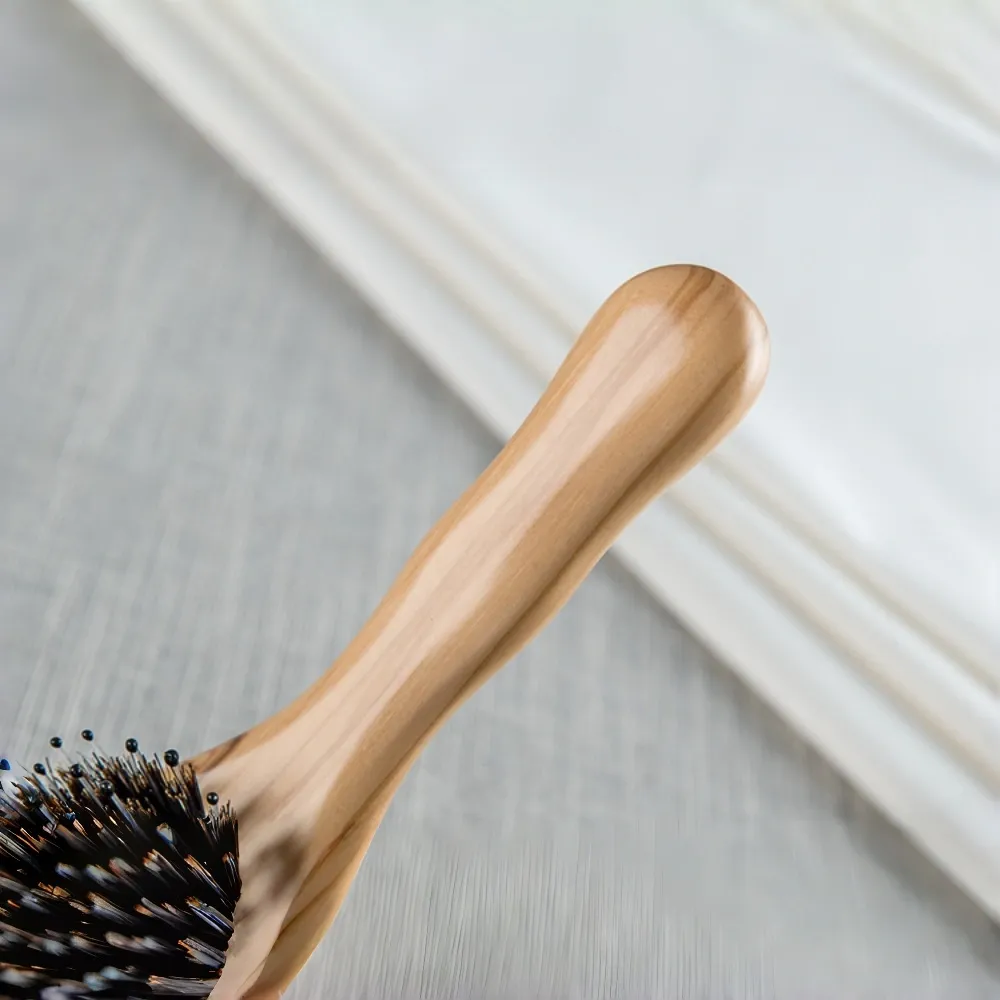 Detailed texture view of BSFL sustainable handcrafted olive wood brush handle.