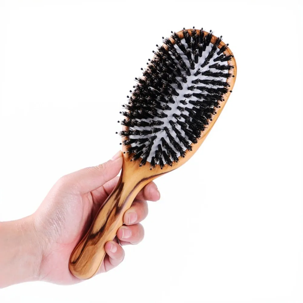 BSFL ergonomic detangling brush held in hand, promoting scalp health and easy styling.